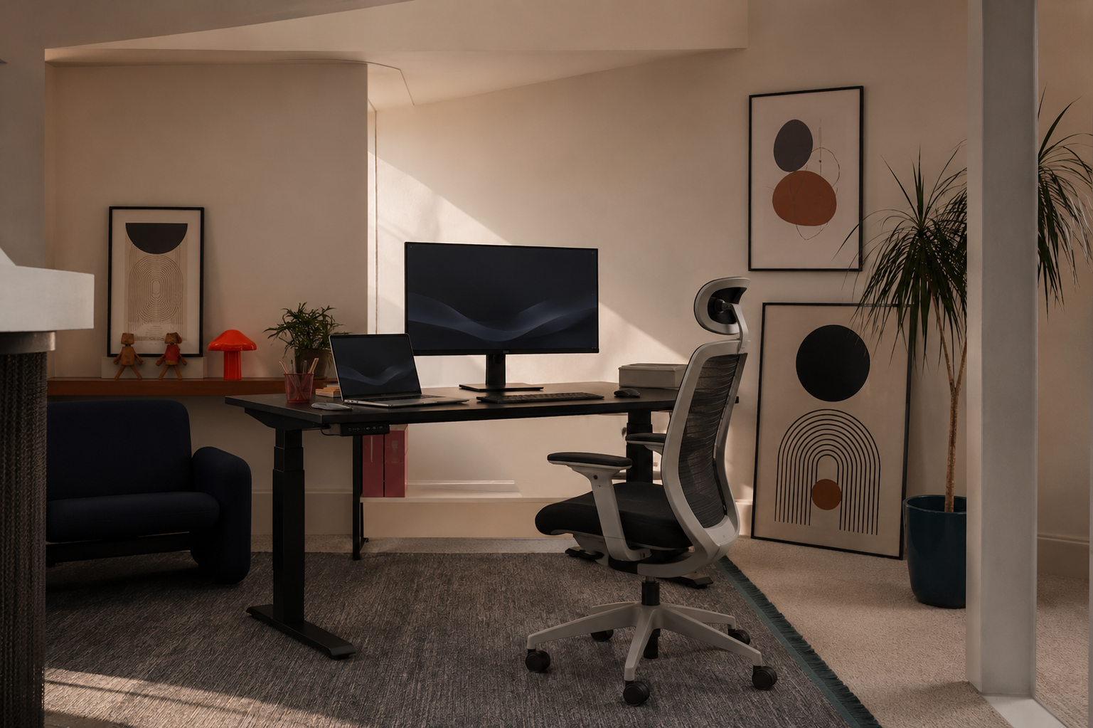 Black standing desk with monitor and laptop in a warmly lit home office with wall art